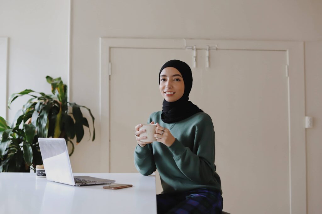 Une entrepreneuse musulmane boit son café.